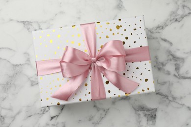 Photo of Gift box with beautiful bow on white marble table, top view