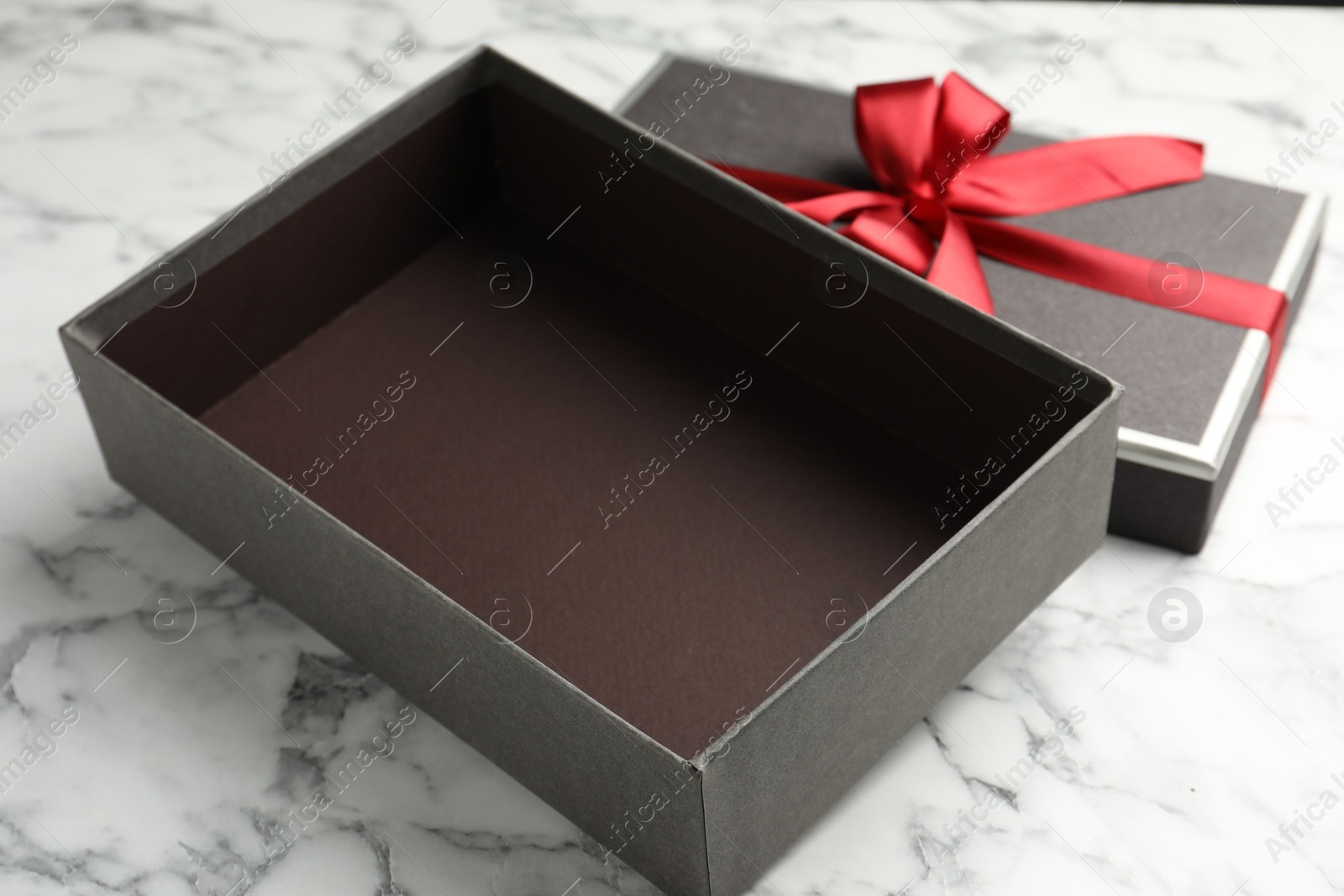 Opened gift box with beautiful lid on white marble table, closeup Photo of Opened gift box with beautiful lid on white marble table, closeup