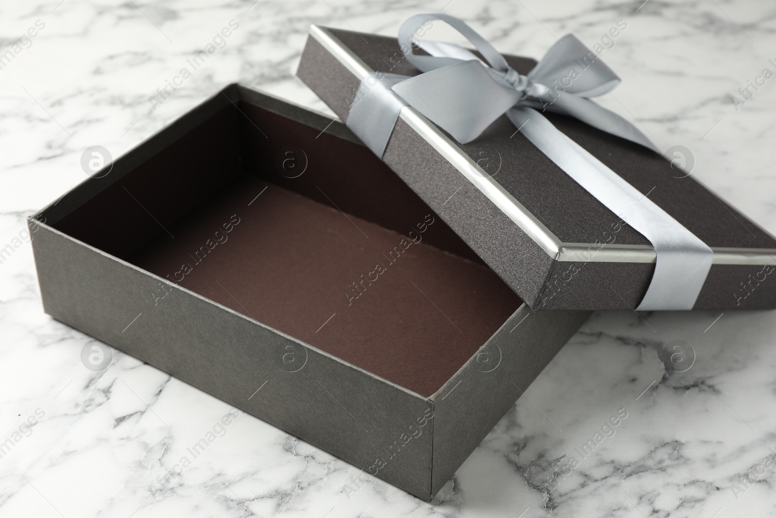 Opened gift box with beautiful lid on white marble table, closeup Photo of Opened gift box with beautiful lid on white marble table, closeup