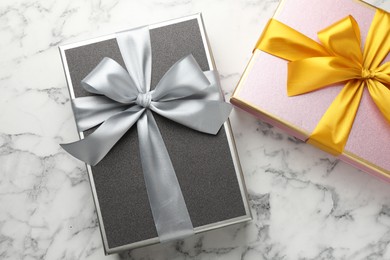 Photo of Gift boxes with beautiful bows on white marble table, top view