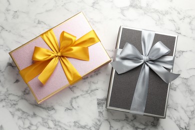 Photo of Gift boxes with beautiful bows on white marble table, top view