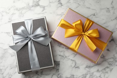 Photo of Gift boxes with beautiful bows on white marble table, top view