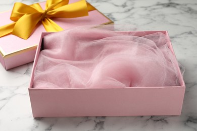 Photo of Opened gift box with beautiful lid on white marble table, closeup