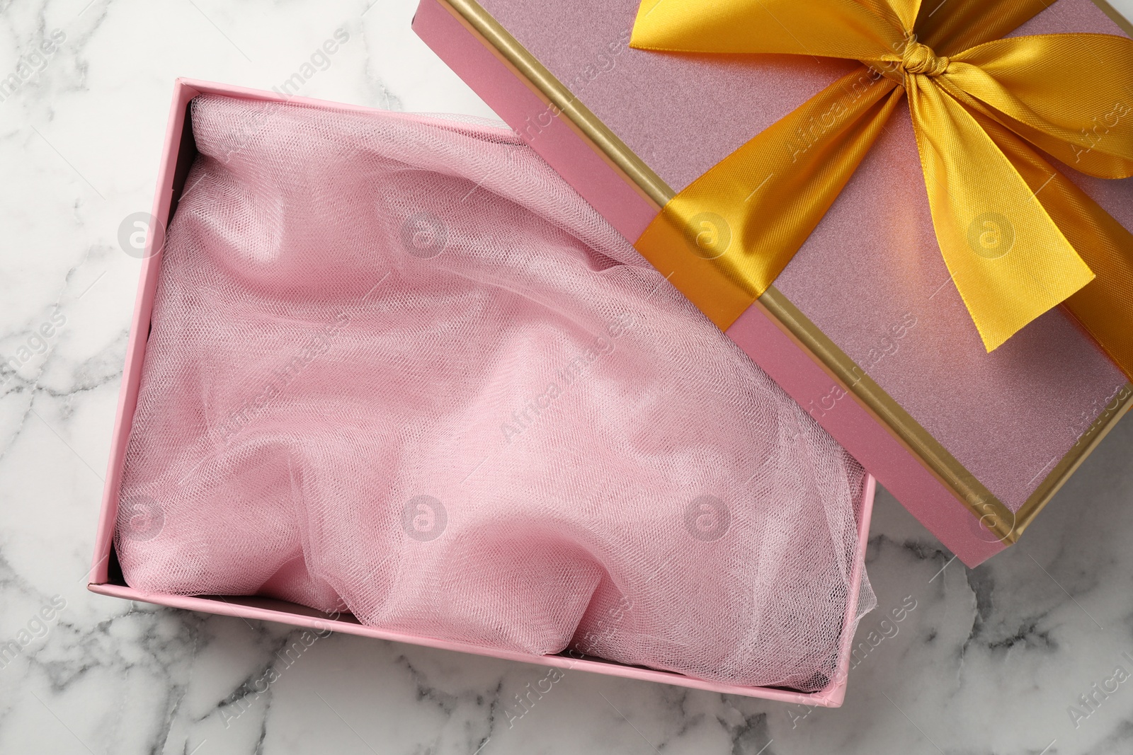 Photo of Opened gift box with beautiful lid on white marble table, top view