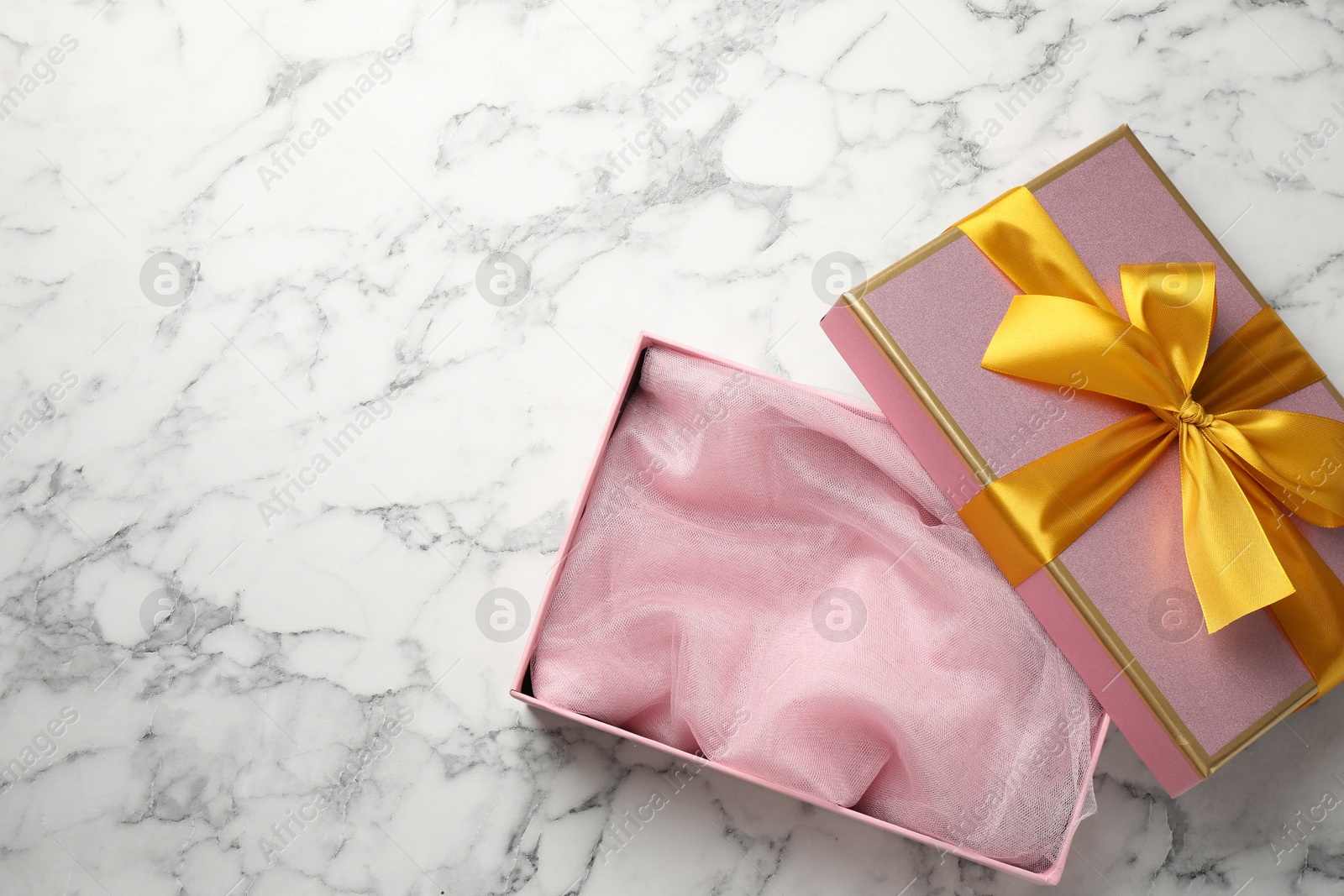 Photo of Opened gift box with beautiful lid on white marble table, top view. Space for text