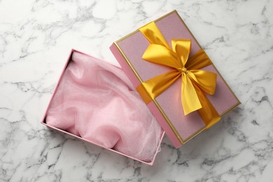 Photo of Opened gift box with beautiful lid on white marble table, top view