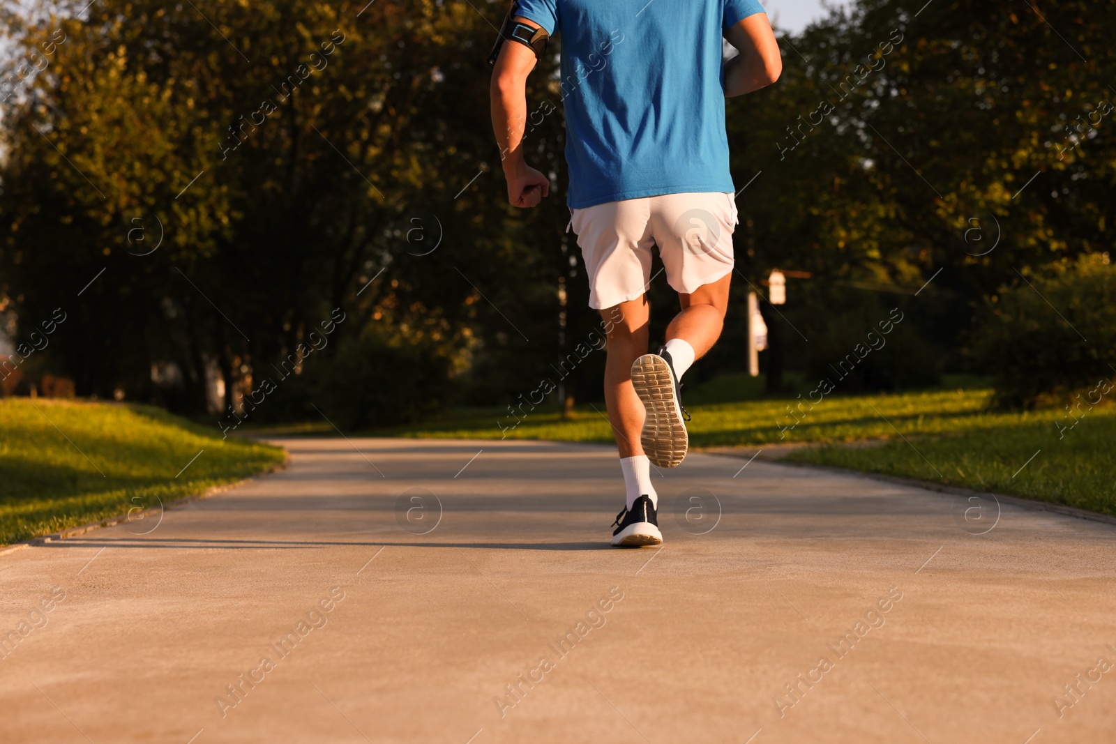 Man running in park on sunny day, closeup. Space for text Photo of Man running in park on sunny day, closeup. Space for text