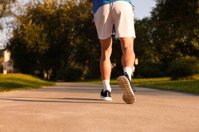Photo of Man running in park on sunny day, closeup. Space for text