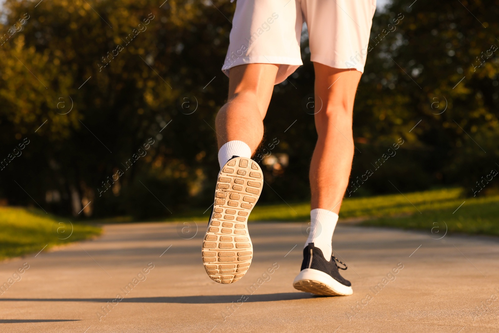 Man running in park on sunny day, closeup. Space for text Photo of Man running in park on sunny day, closeup. Space for text