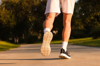 Photo of Man running in park on sunny day, closeup. Space for text