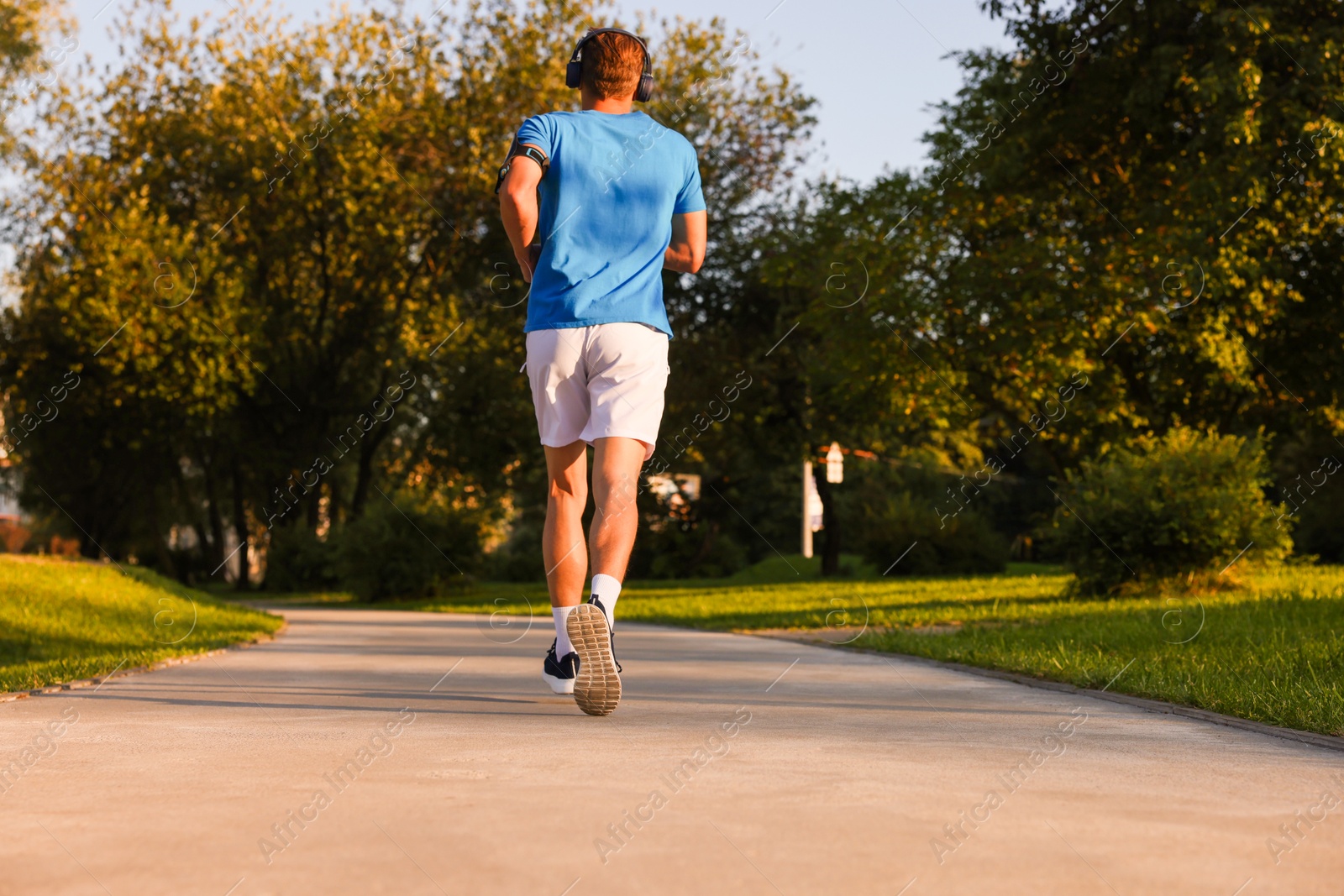 Man running in park on sunny day, low angle view Photo of Man running in park on sunny day, low angle view
