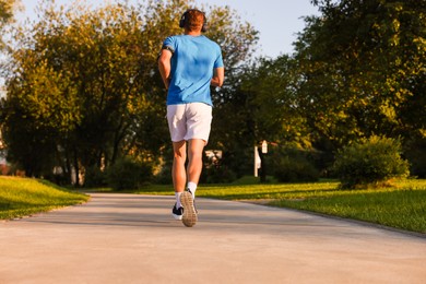 Photo of Man running in park on sunny day, low angle view