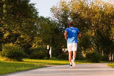 Photo of Man running in park on sunny day, low angle view