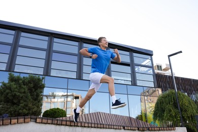 Photo of Man running on city street, low angle view