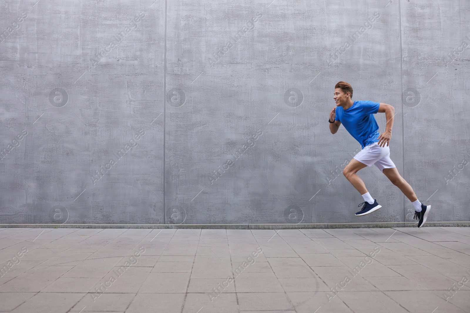 Man running near building on city street, space for text Photo of Man running near building on city street, space for text