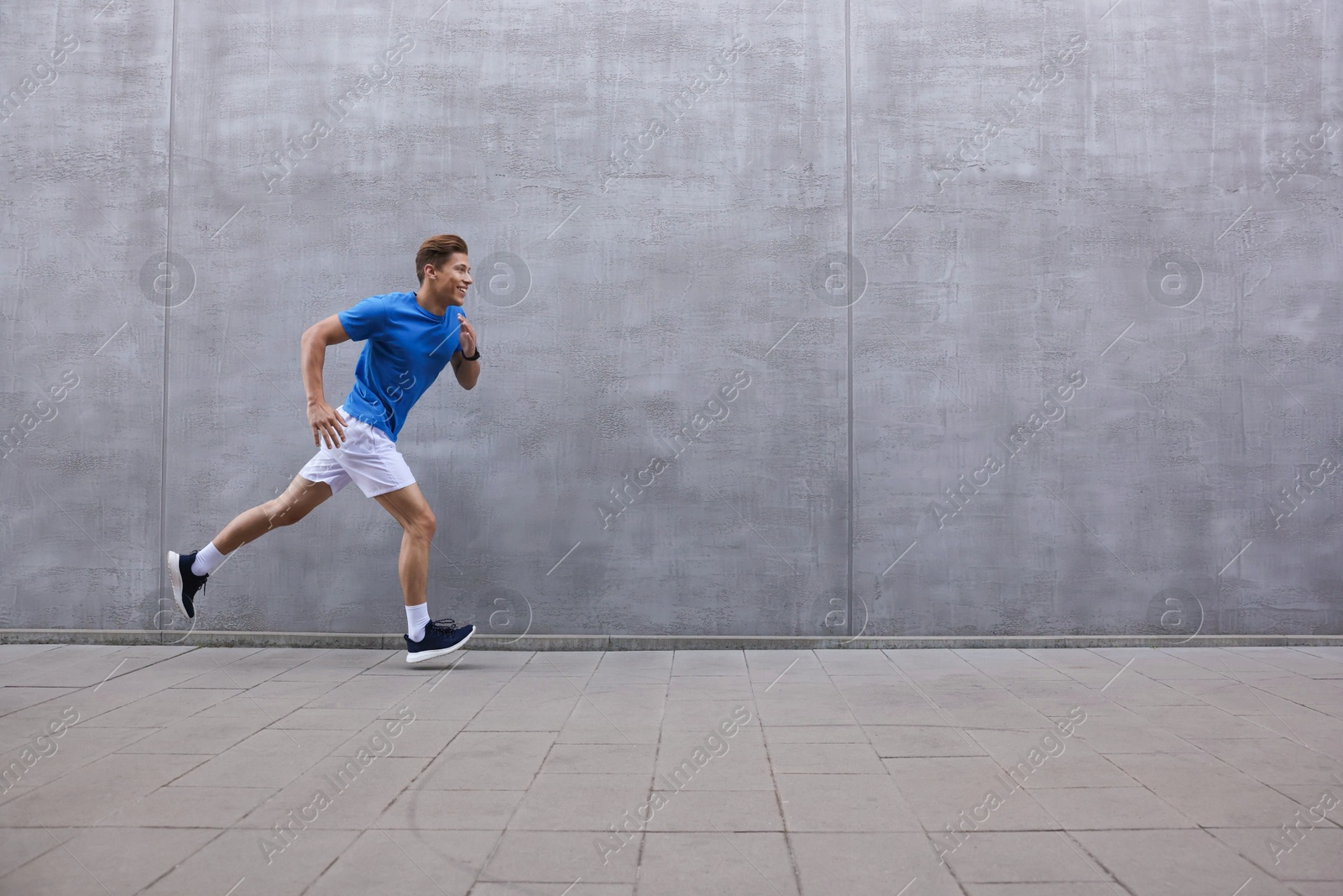Man running near building on city street, space for text Photo of Man running near building on city street, space for text