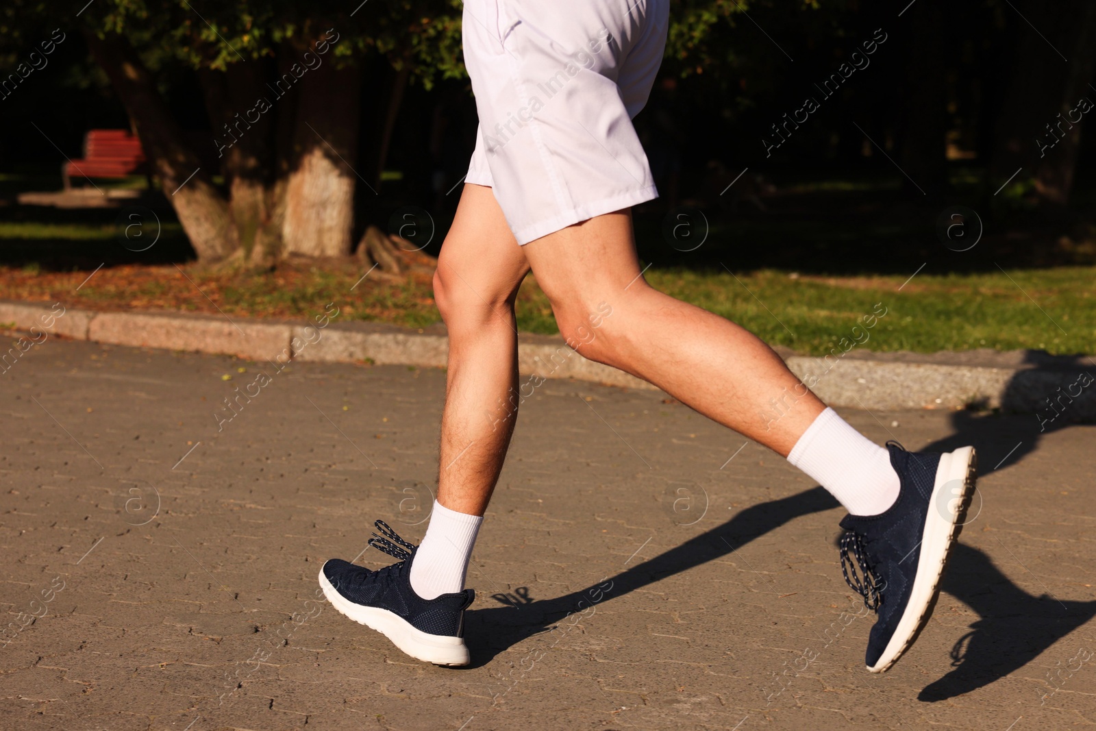 Photo of Man in stylish sneakers outdoors on sunny day, closeup