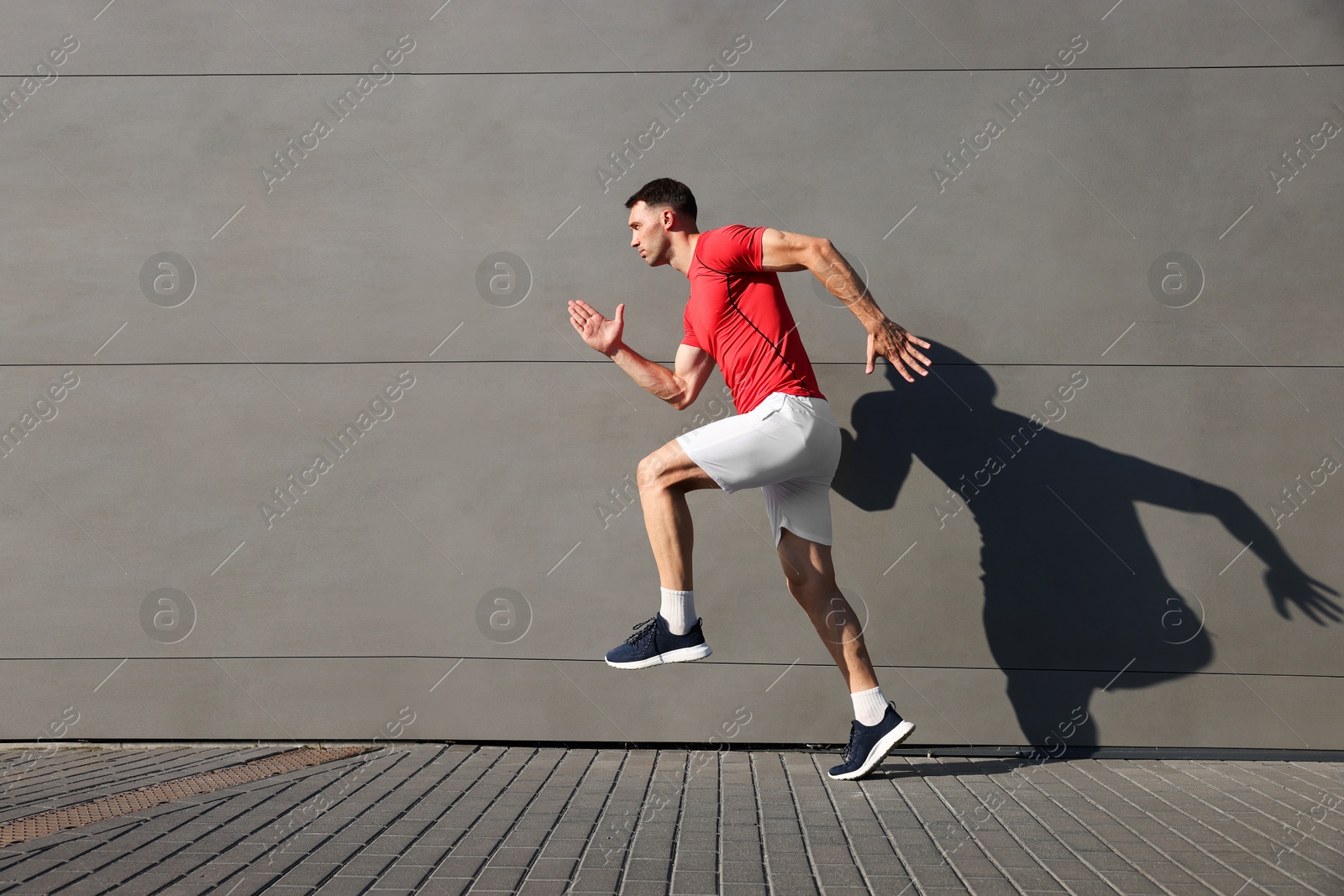 Photo of Man in sportswear running near building outdoors, space for text