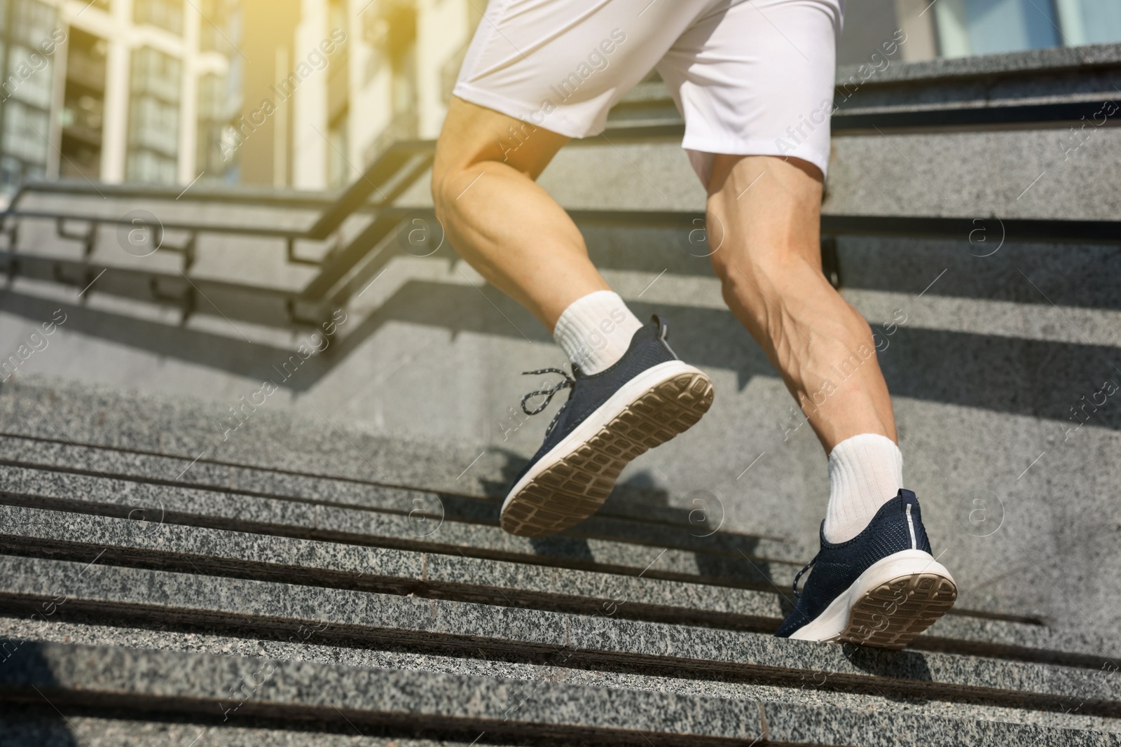 Photo of Man in sportswear running up on stairs outdoors, low angle view. Space for text