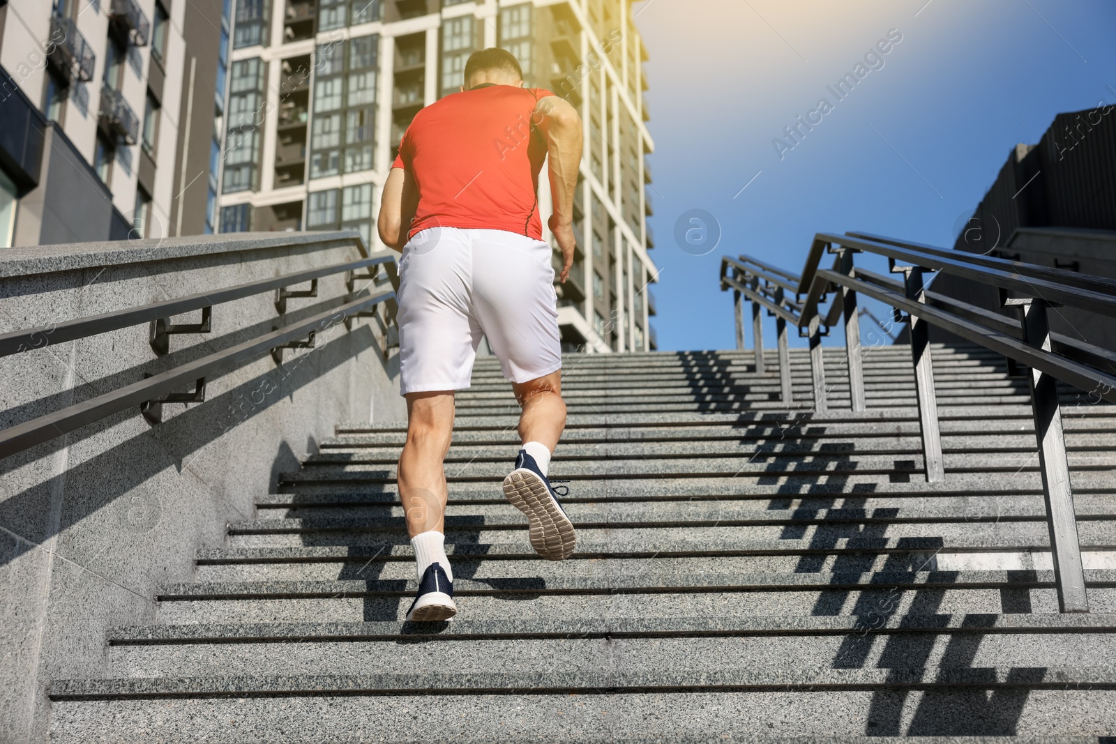Man in sportswear running up on stairs outdoors, low angle view Photo of Man in sportswear running up on stairs outdoors, low angle view