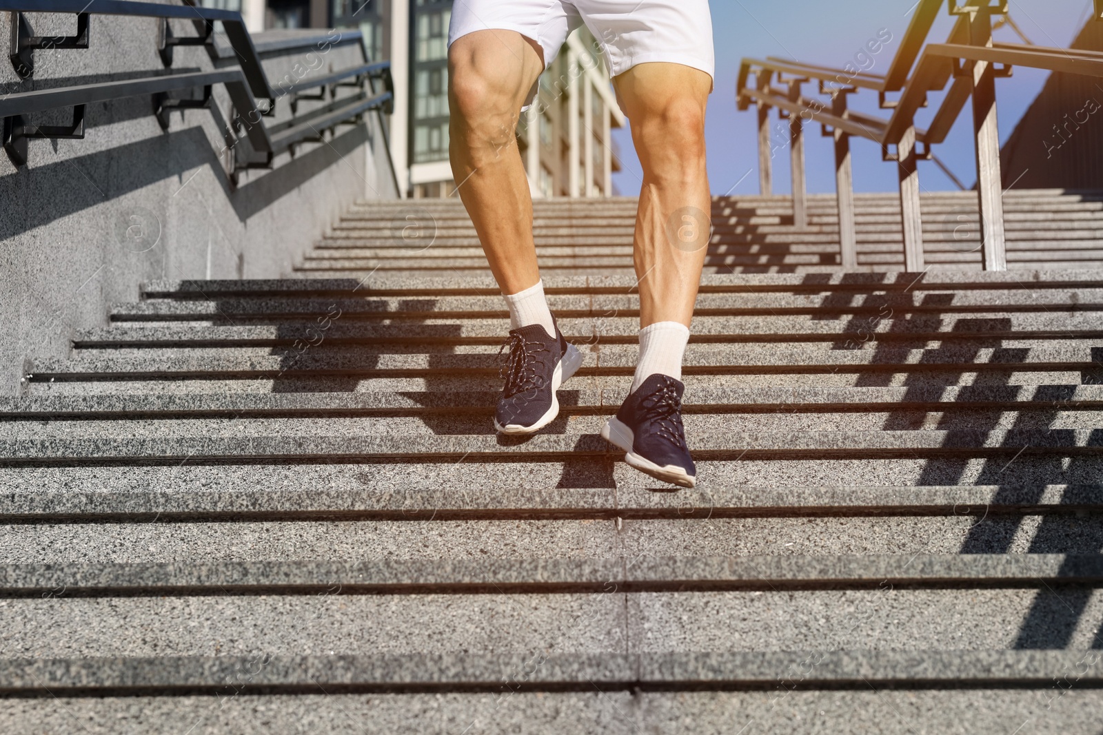 Man in sportswear running down on stairs outdoors, closeup Photo of Man in sportswear running down on stairs outdoors, closeup