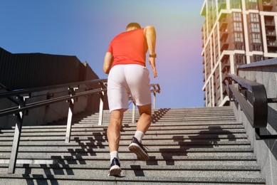 Photo of Man in sportswear running up on stairs outdoors, low angle view