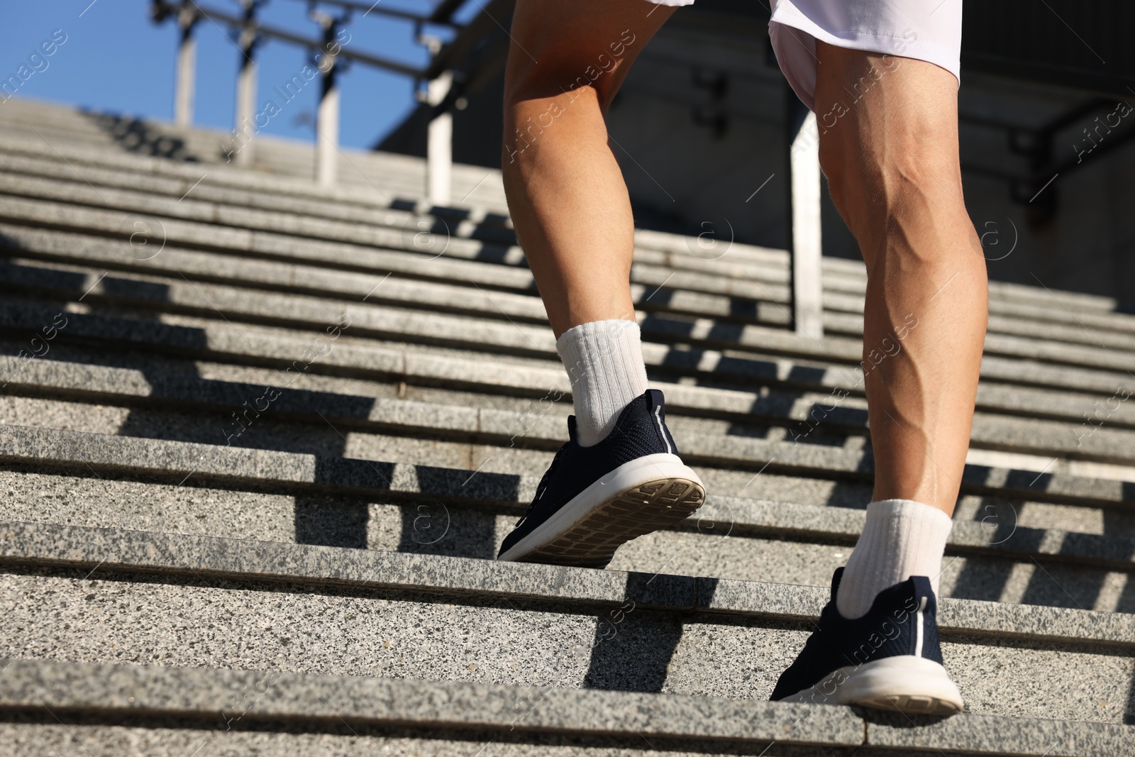 Photo of Man in sportswear running up on stairs outdoors, low angle view. Space for text