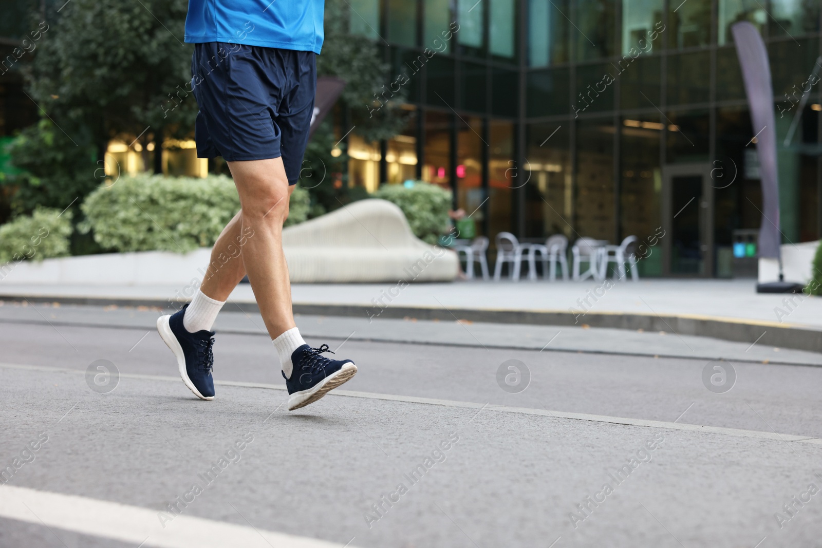 Photo of Man in sportswear running outdoors, closeup. Space for text