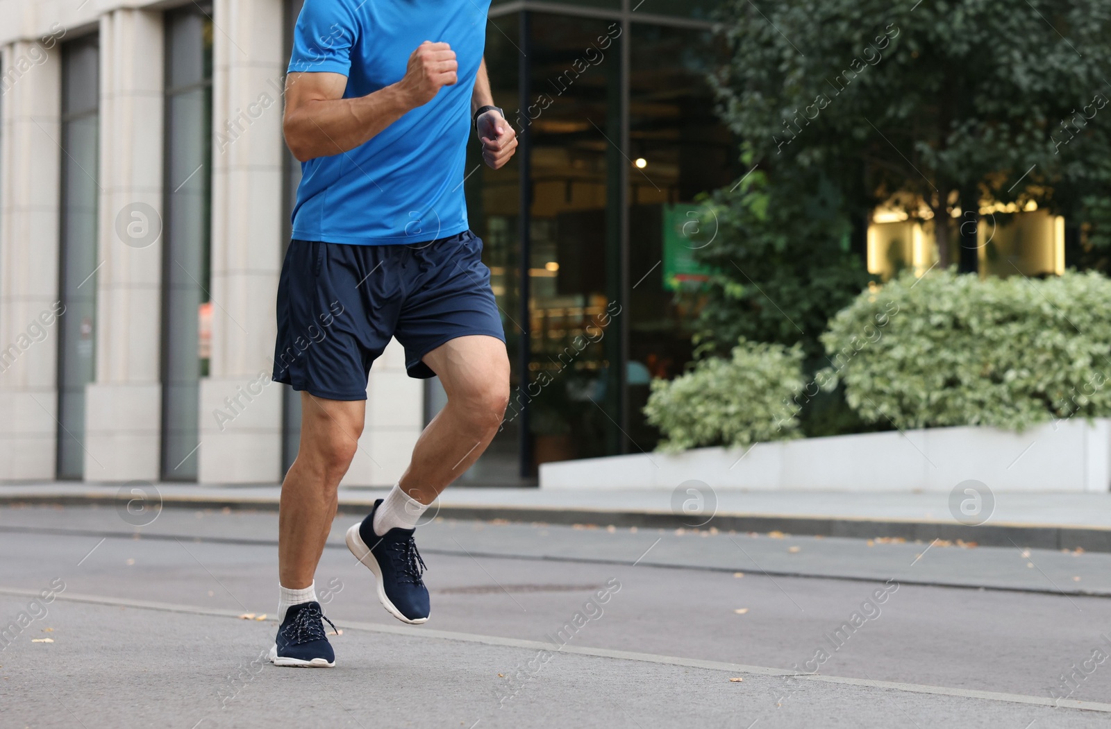 Photo of Man in sportswear running outdoors, closeup. Space for text