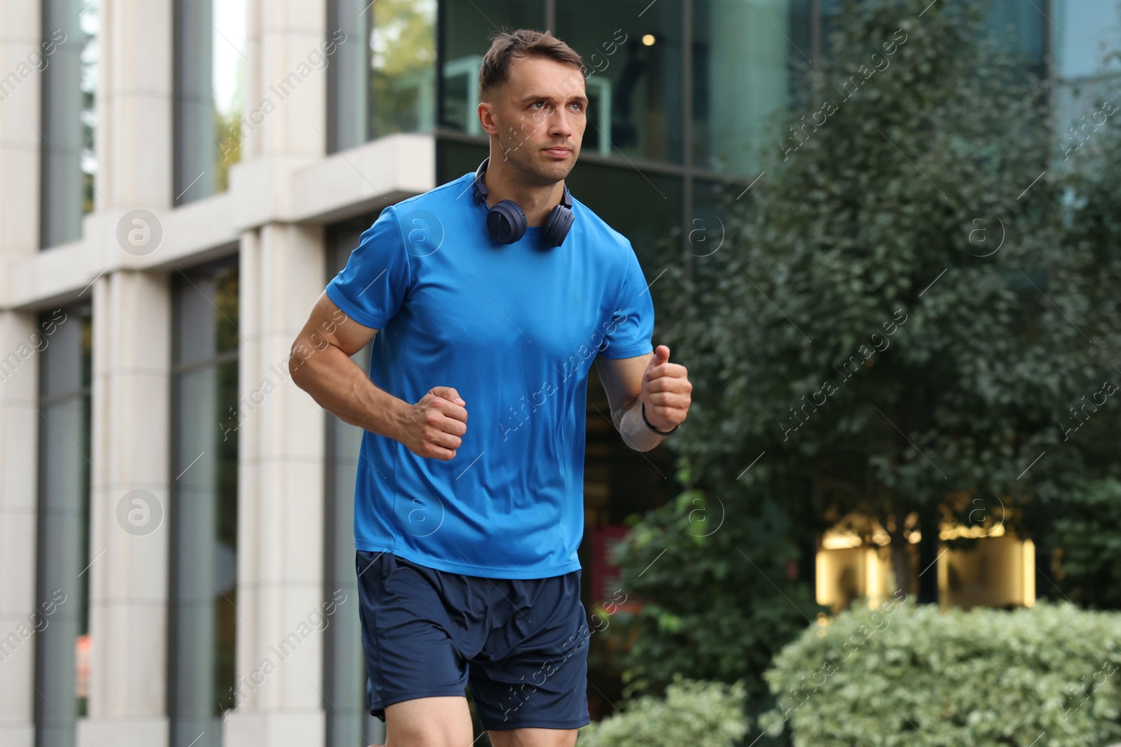 Photo of Man in sportswear running on city street