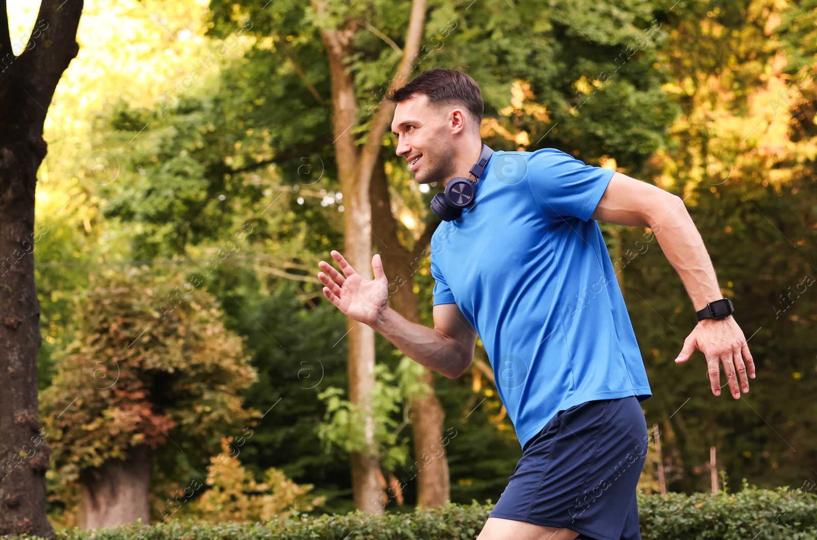 Man in sportswear running outdoors, space for text Photo of Man in sportswear running outdoors, space for text