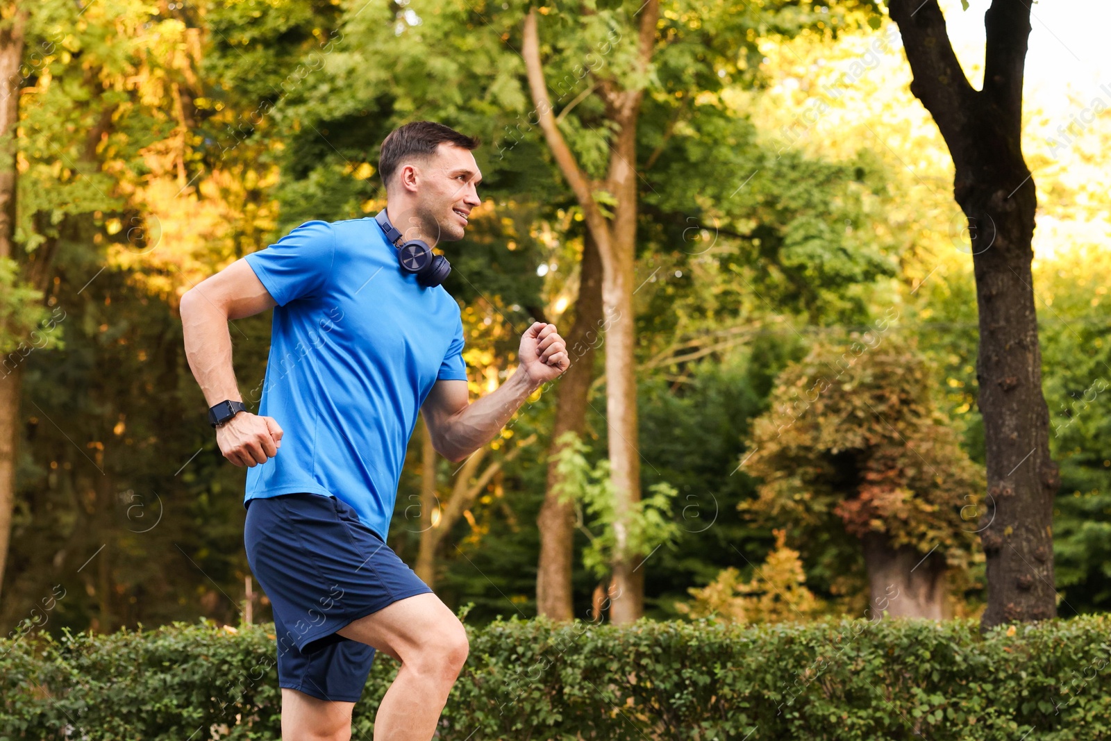 Photo of Man in sportswear running outdoors, space for text