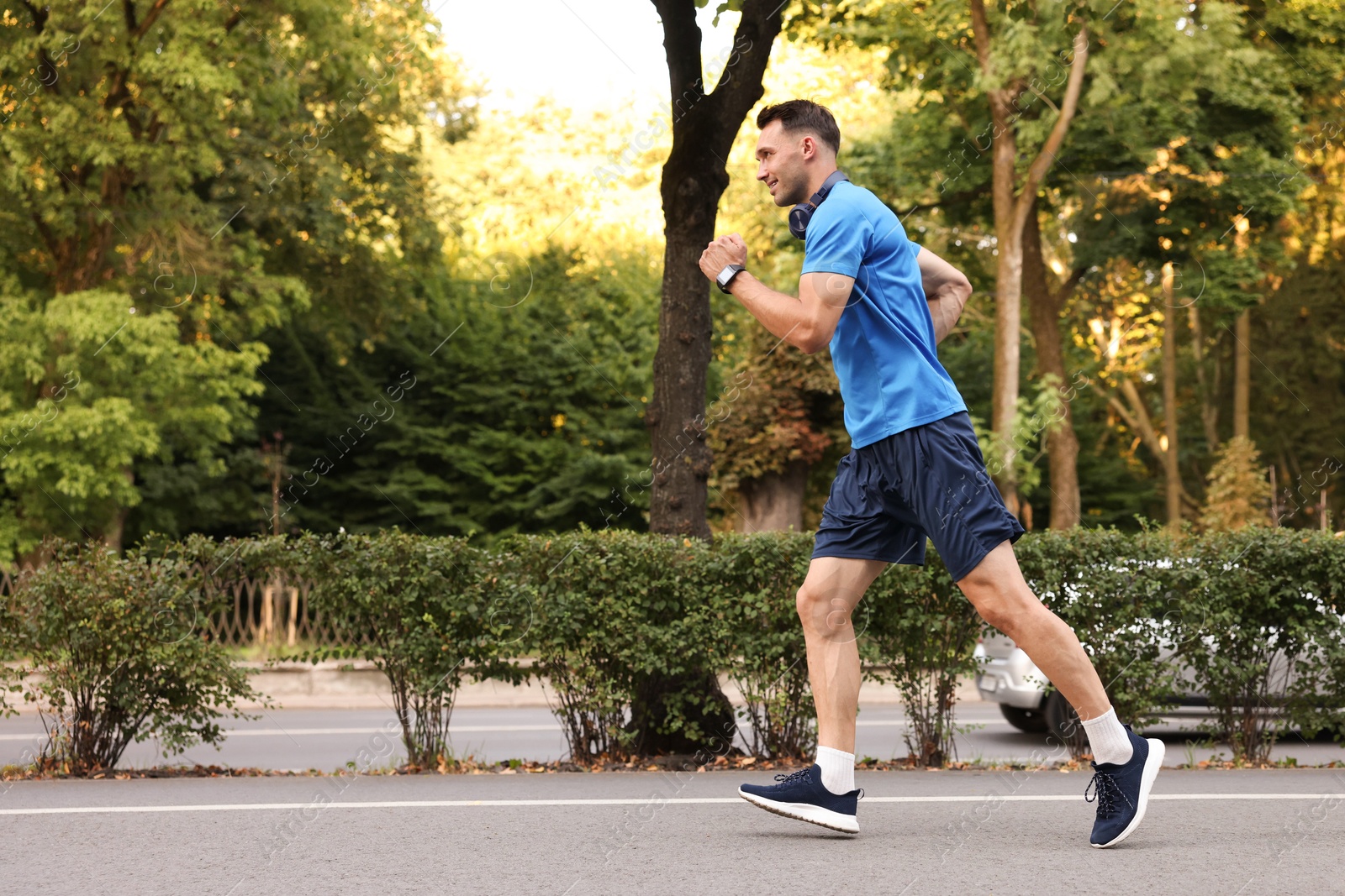 Photo of Man in sportswear running outdoors, space for text