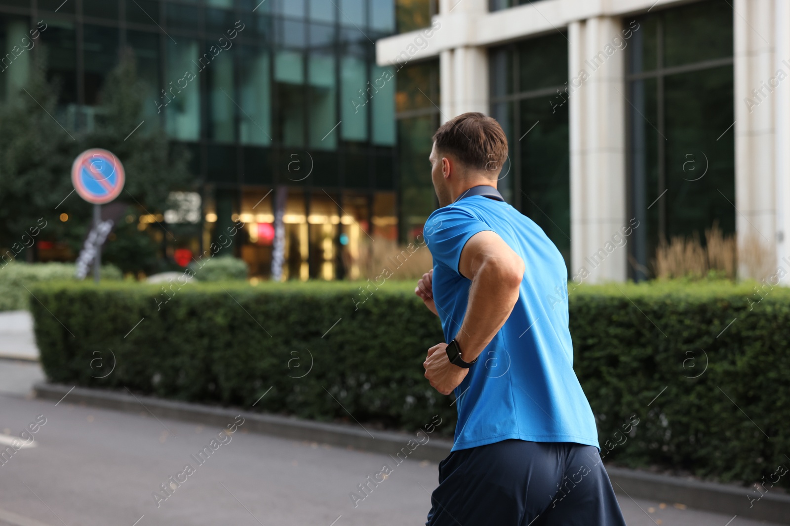 Man in sportswear running outdoors, back view Photo of Man in sportswear running outdoors, back view