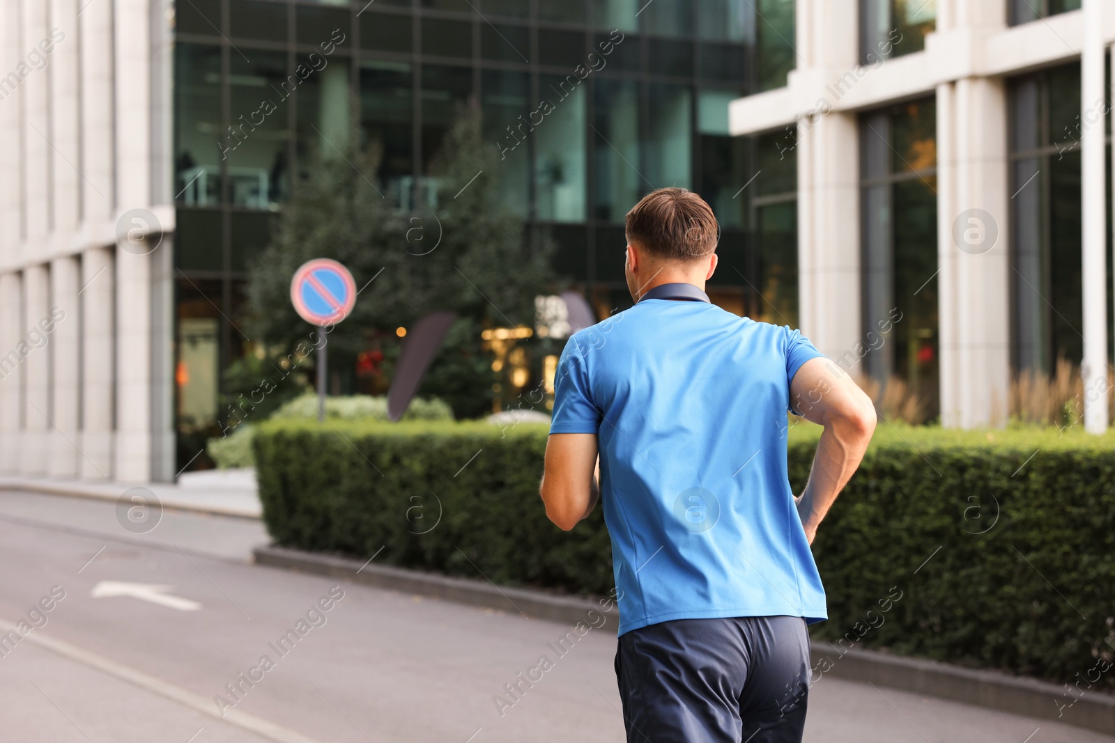 Man in sportswear running outdoors, back view Photo of Man in sportswear running outdoors, back view