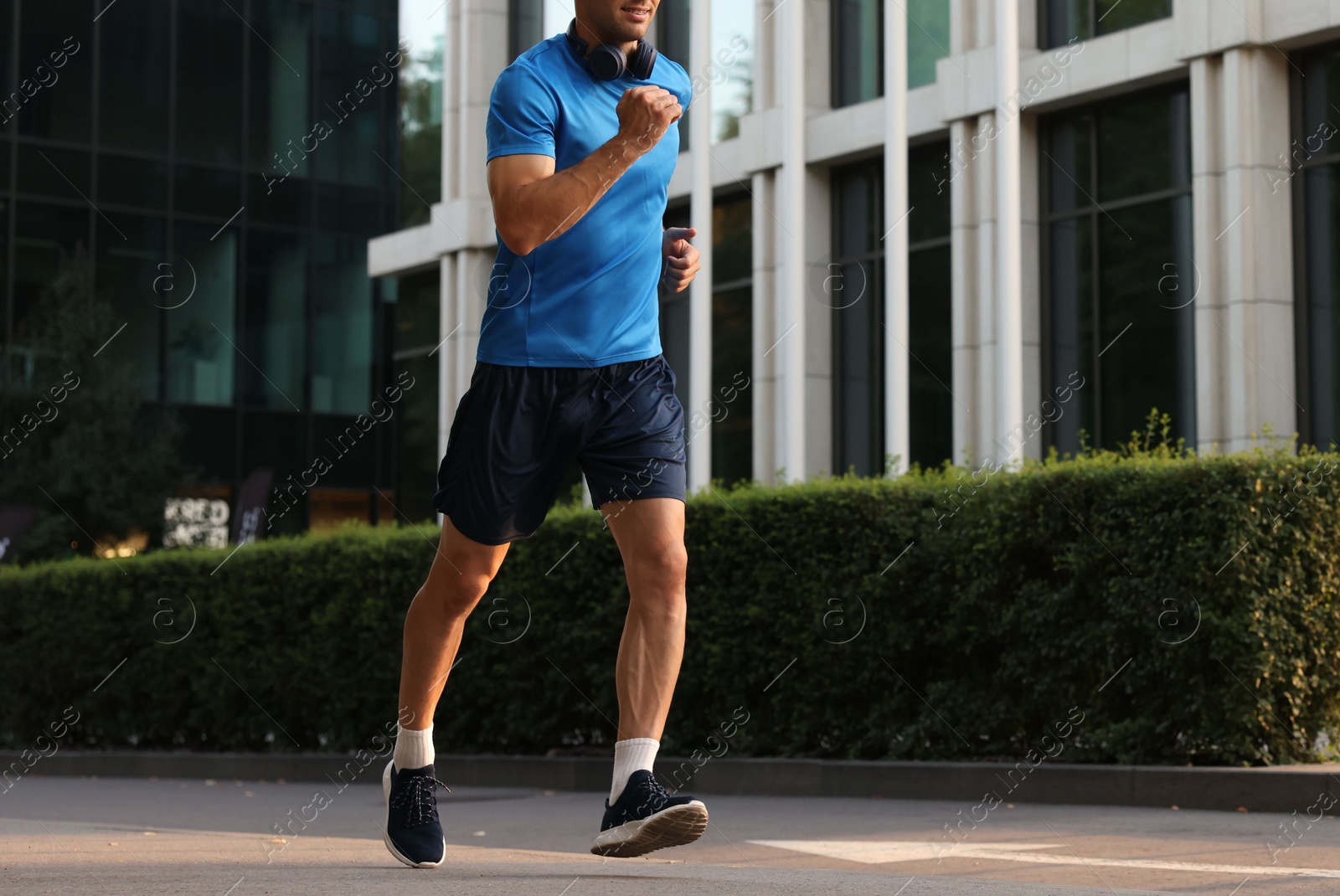 Photo of Man in sportswear running on city street, closeup. Space for text