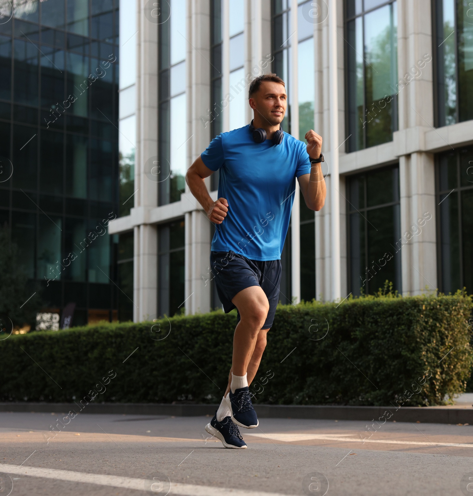 Photo of Man in sportswear running on city street