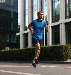 Photo of Man in sportswear running on city street