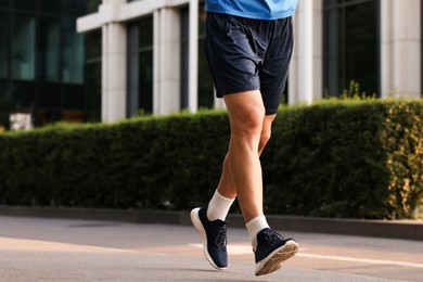 Photo of Man in sportswear running on city street, closeup. Space for text