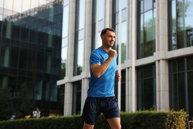 Photo of Man in sportswear running on city street