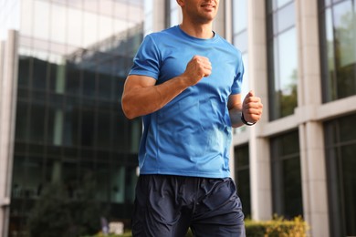 Photo of Man in sportswear running outdoors, low angle view