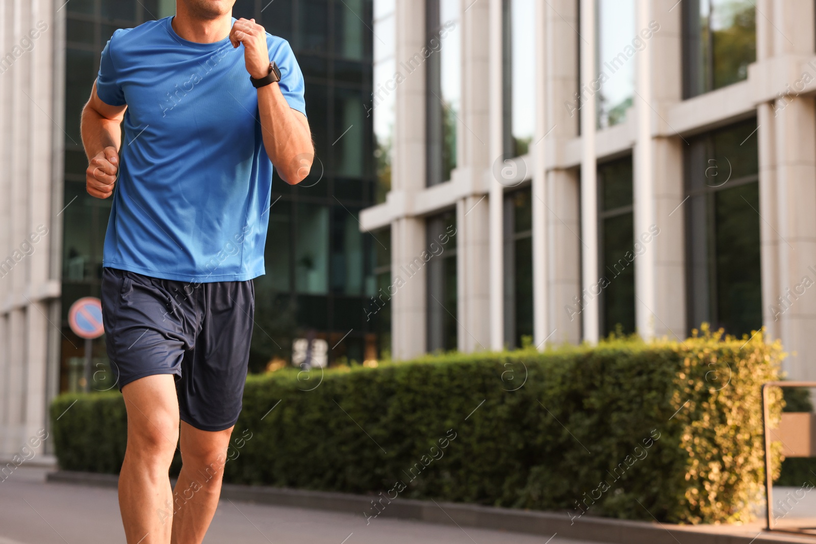 Photo of Man in sportswear running outdoors, closeup. Space for text
