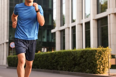 Photo of Man in sportswear running outdoors, closeup. Space for text