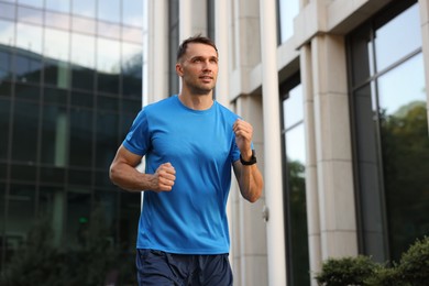 Photo of Man in sportswear running outdoors, low angle view