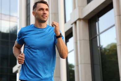 Photo of Man in sportswear running outdoors, low angle view. Space for text