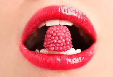 Photo of Woman with beautiful lips makeup and raspberry candy, closeup