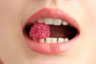 Photo of Woman with beautiful lips makeup and raspberry candy, closeup