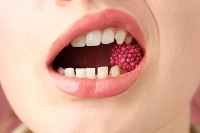 Photo of Woman with beautiful lips makeup and raspberry candy, closeup
