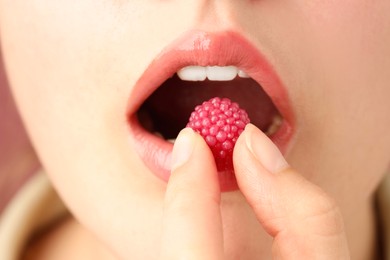 Photo of Woman with beautiful lips makeup and raspberry candy, closeup