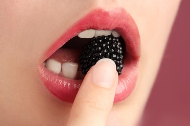 Photo of Woman with beautiful lips makeup and blackberry on color background, closeup